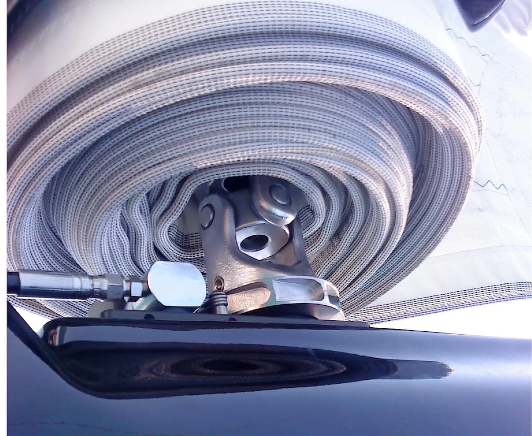 Close-up of coiled rope and sailboat deck hardware used in running rigging systems